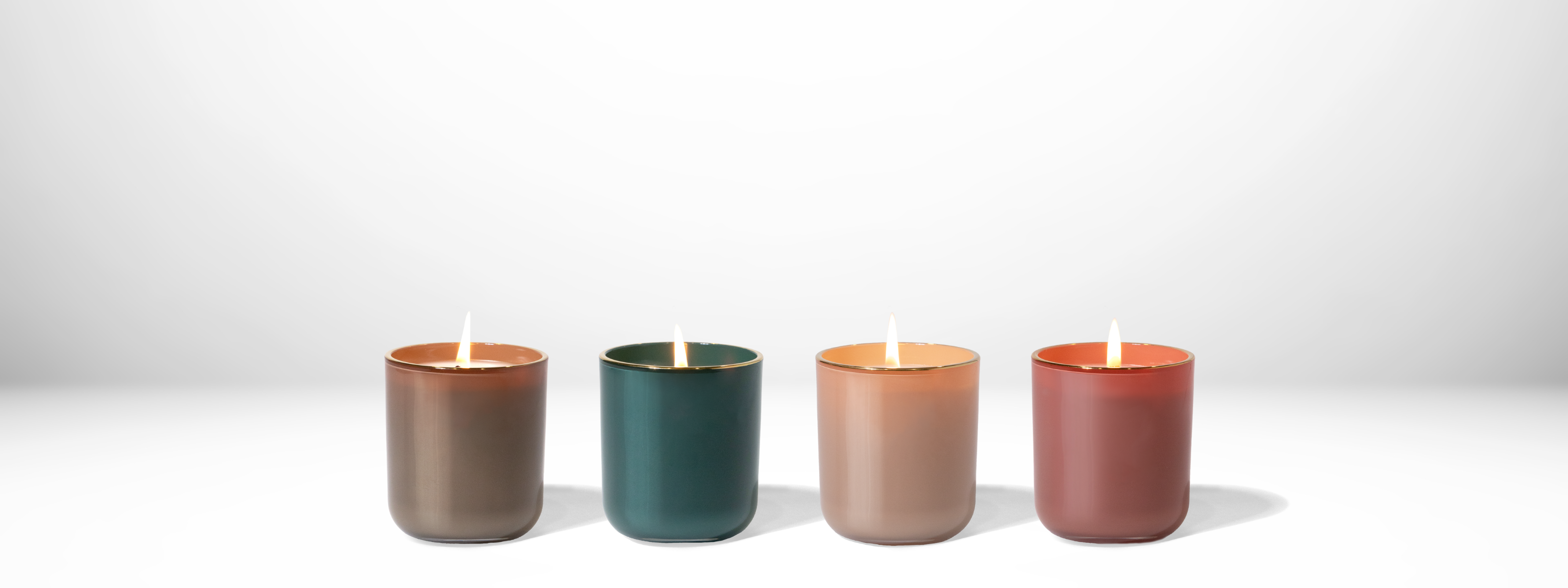 Four candles of different colors arranged in a row on a white background